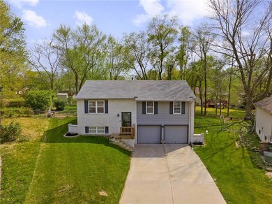 Raised ranch with a front lawn and a garage