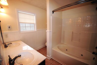 Private master bath has double sinks and tile flooring