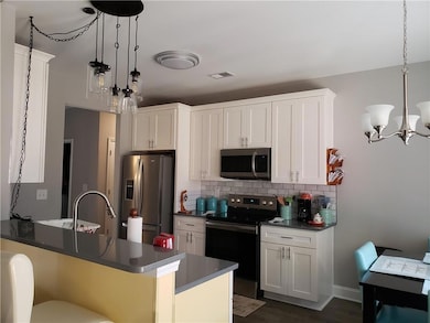 Kitchen featuring pendant lighting, white cabinetr