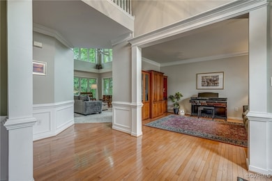 Entryway with ornate columns, light wood-style flo