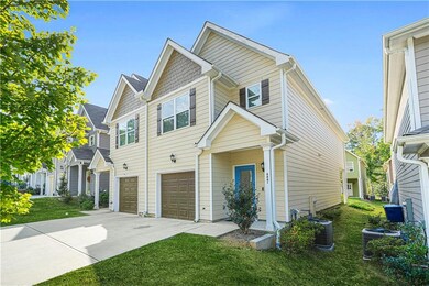 View of front of house featuring an attached garage, concrete driveway, a front yard, and a residential view