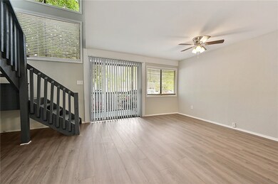 Spacious living room featuring stairway, baseboard