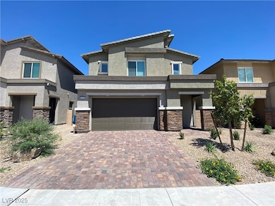 Prairie-style house with stone siding, stucco siding, decorative driveway, and a garage