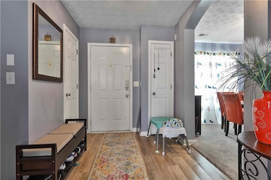 Entryway featuring a textured ceiling and light ha