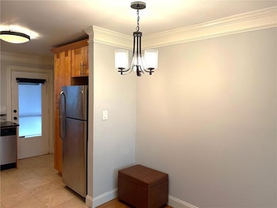 Kitchen featuring stainless steel appliances, a chandelier, ornamental molding, decorative light fixtures, and baseboards