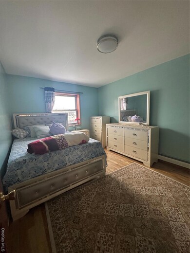 Bedroom featuring light wood finished floors and a baseboard radiator