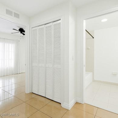 Corridor with light tile patterned flooring and ba