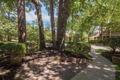 Just outside the front door is a stone paved patio area partially secluded with landscaping and tall mature trees.