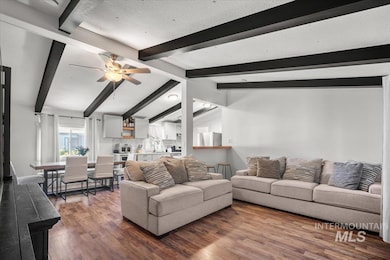 Living room featuring dark wood-style flooring and a ceiling fan