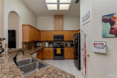 Kitchen featuring electric range oven, tasteful backsplash, light tile floors, and granite counters