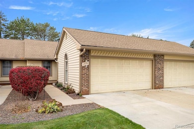 View of front of house featuring brick siding, a shingled roof, and concrete driveway