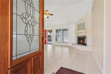 Unfurnished living room with light tile patterned flooring, vaulted ceiling, a fireplace, baseboards, and ceiling fan