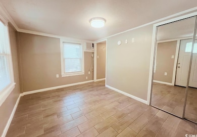 Unfurnished bedroom with ornamental molding, light