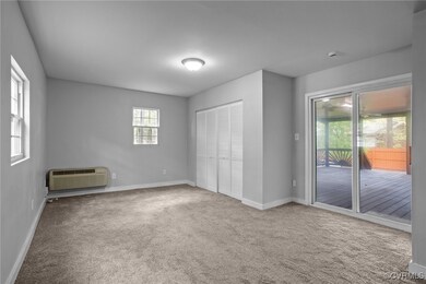 Unfurnished bedroom with baseboards, carpet, acces