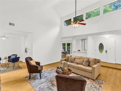 Living room featuring ceiling fan, high vaulted ce