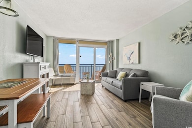Living room with a textured wall, a textured ceiling, floor to ceiling windows, and wood tiled floors