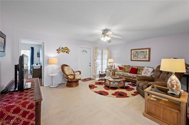 Living room featuring a ceiling fan, plenty of nat