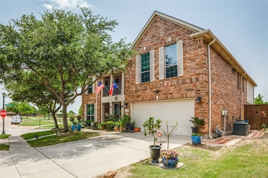 Traditional-style house with brick siding, driveway, a balcony, and a garage