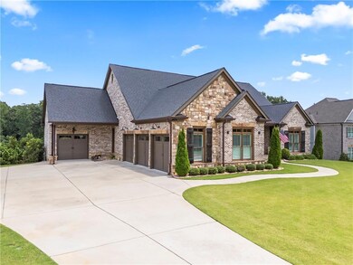 Four Car side garage featuring brick siding, roof with shingles, driveway, and a front yard