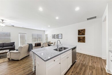 Kitchen with a center island with sink, white cabi