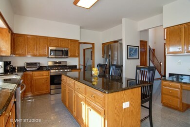 Sunny kitchen work area which features granite cou