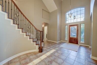 Two-story foyer flooded in natural light through transom windows welcomes guests into this stunning home.
