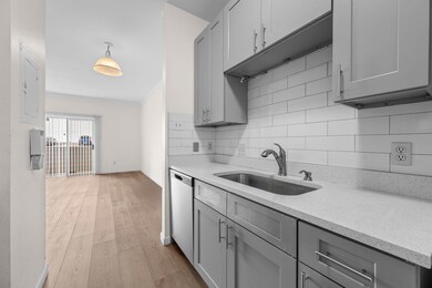 Kitchen with a sink, gray cabinetry, stainless st