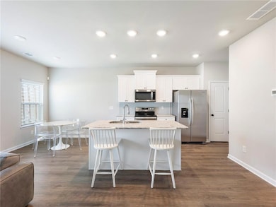 Kitchen with dark wood-type flooring, appliances w