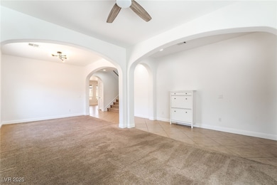 Empty room featuring carpet, ceiling fan, tile pat