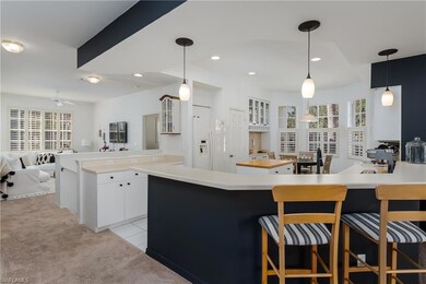 Kitchen with white cabinetry, white fridge with ic