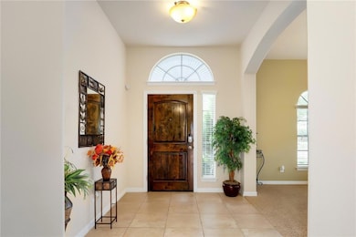Tiled entrance foyer featuring arched walkways an