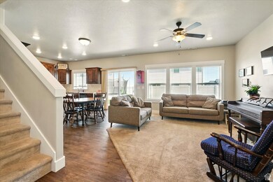 Living area with a ceiling fan, wood finished floors, stairway, and recessed lighting