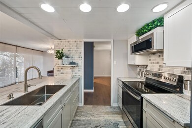 Kitchen featuring light stone countertops, applian