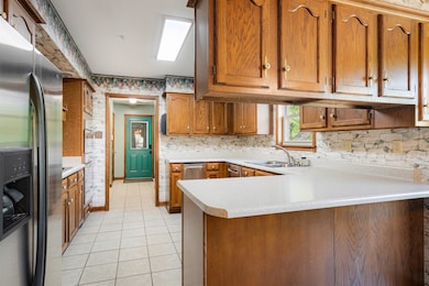 Kitchen featuring a sink, brown cabinets, stainles