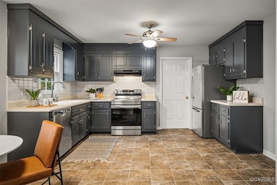 Kitchen featuring ceiling fan, sink, appliances wi