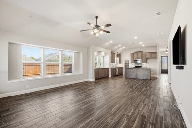 Unfurnished living room featuring vaulted ceiling, recessed lighting, wood finish floors, a ceiling fan, and arched walkways