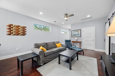 Living room featuring ceiling fan, dark wood fini