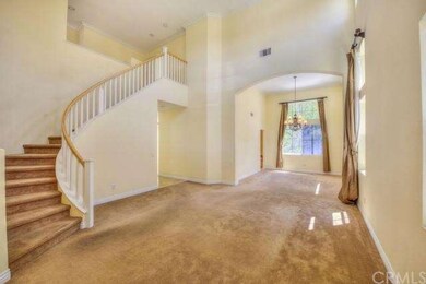 Soaring ceilings and elegant curved stairs welcome