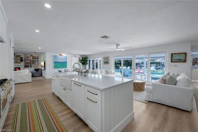 Kitchen featuring a center island with sink, white