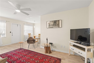 Sitting room with light wood-style floors and ceiling fan
