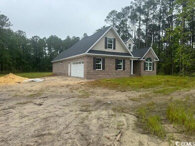 Traditional home with dirt driveway, an attached garage, and brick siding