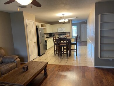 Dining space featuring baseboards, light wood-style flooring, and ceiling fan with notable chandelier