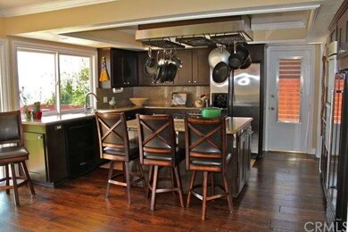 Rich, dark wood kitchen with granite counters, cen