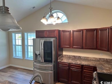 Kitchen with decorative light fixtures, visible ve