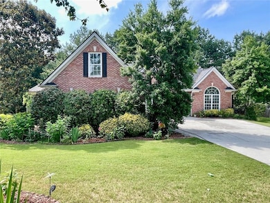 Traditional-style house with brick siding, a front lawn, and driveway