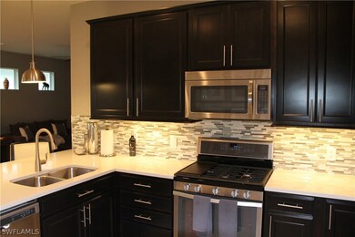 Kitchen has lots of large cabinets and a tiled bac