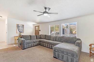 Carpeted living room featuring a textured ceiling and a ceiling fan