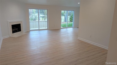 Unfurnished living room featuring a premium fireplace and light wood-style floors