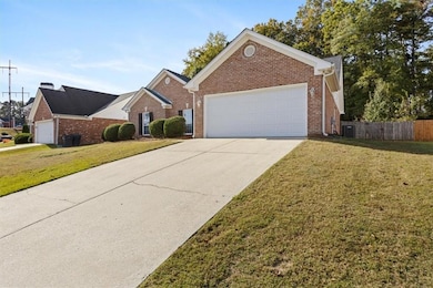 Ranch-style house featuring brick siding, a garage, and concrete driveway