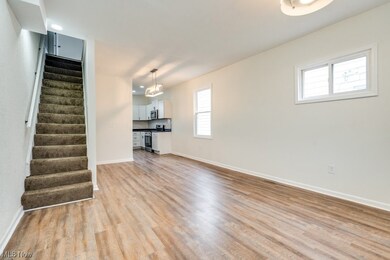 Unfurnished living room with light hardwood / wood-style floors and a notable chandelier